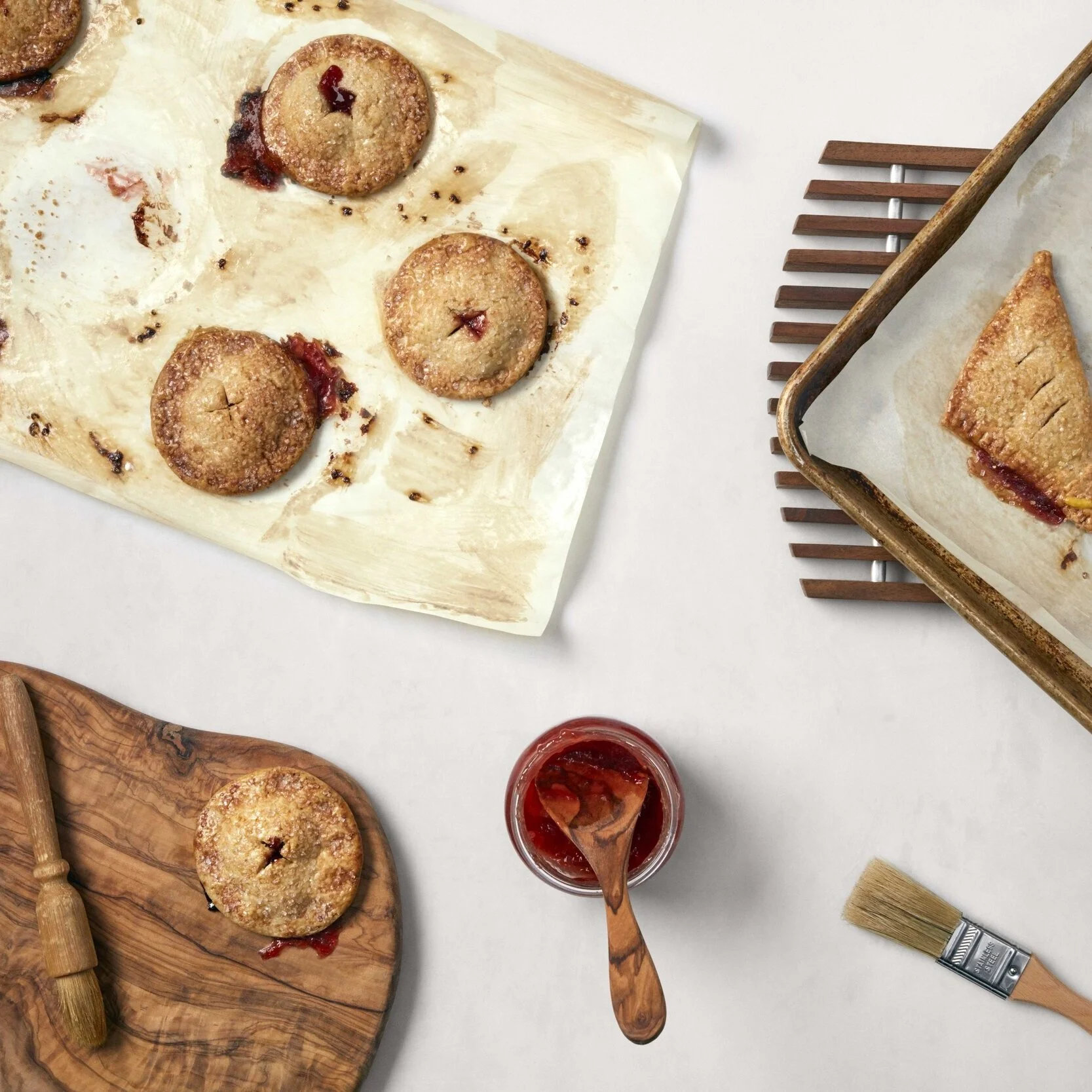 Freshly baked French pastries, apricot jam and baking trays at Petite Baguette